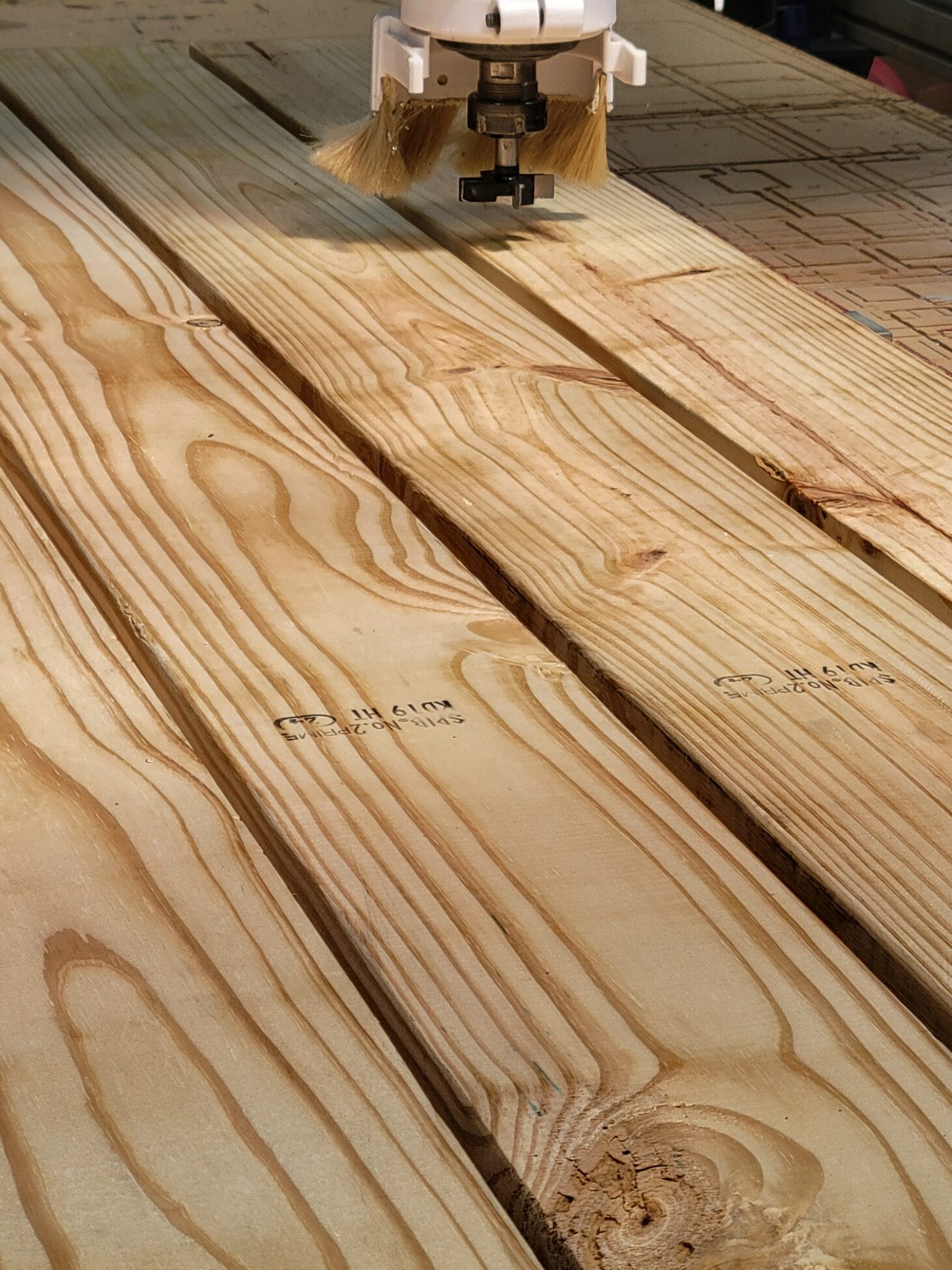 wood slats side by side being cut by cnc machine with a surfacing bit