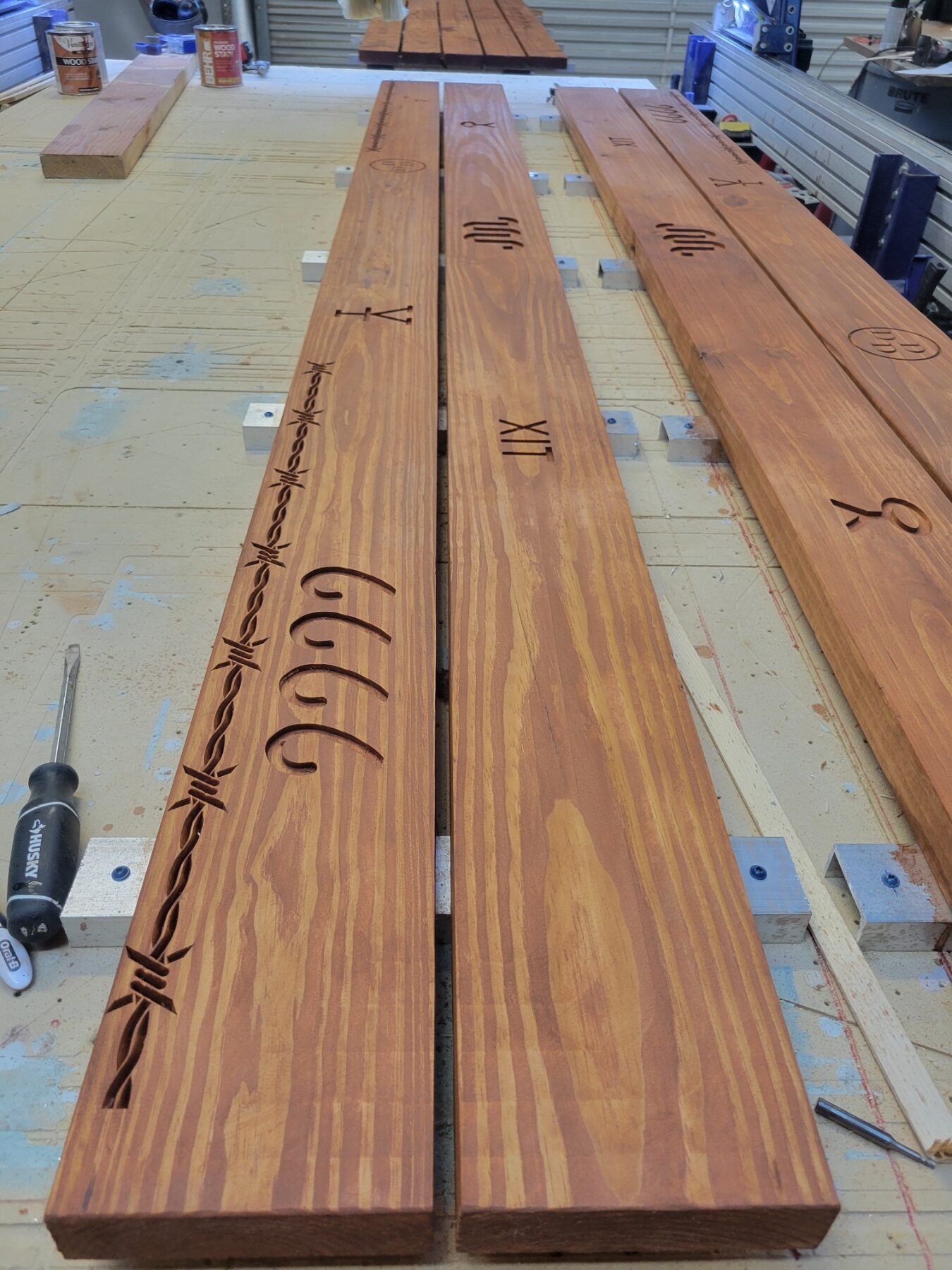 slats from picnic table with engravings of cattle brands and barbed wire, pre assembly