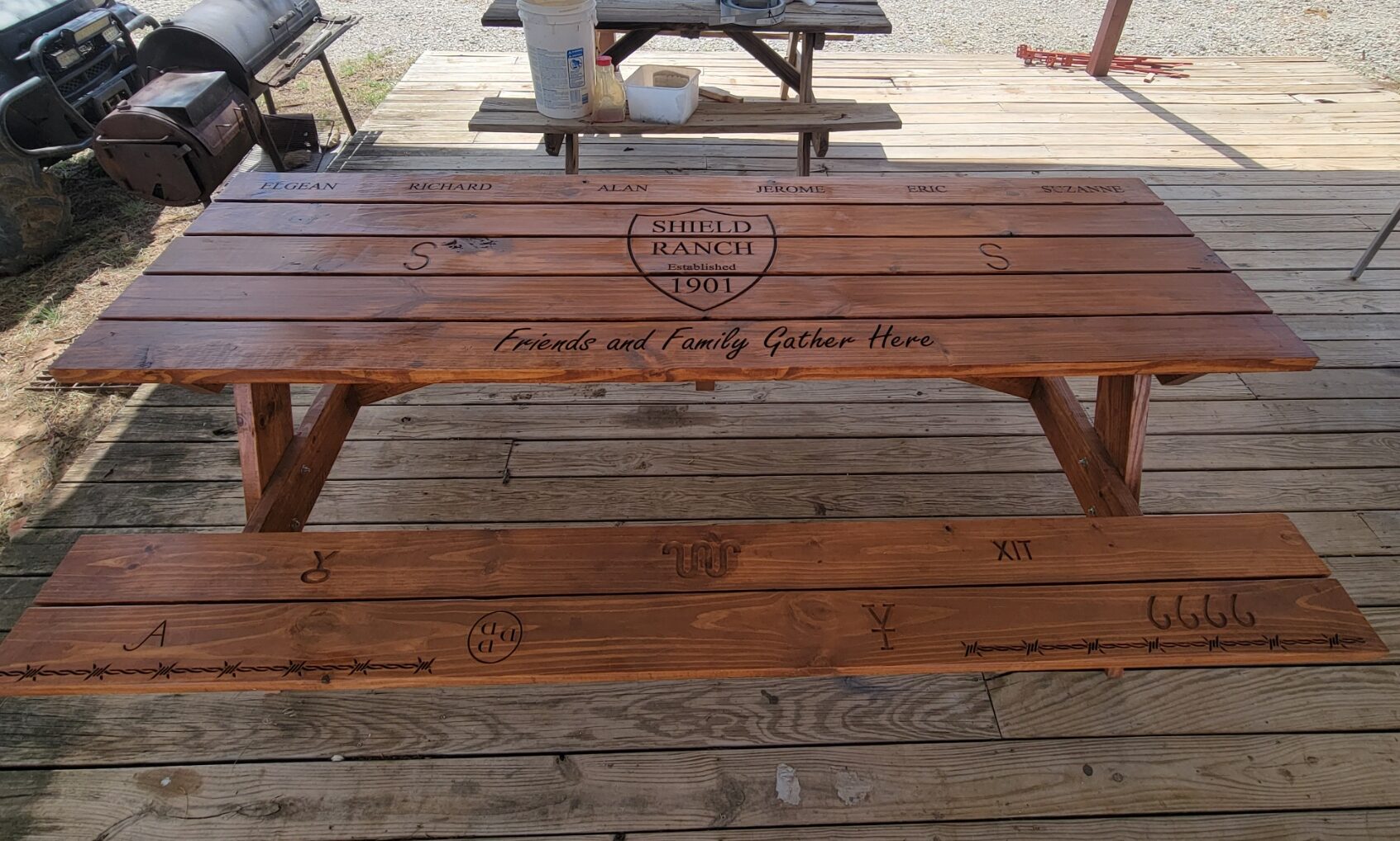 a wooden picnic table, engraved with a ranch logo