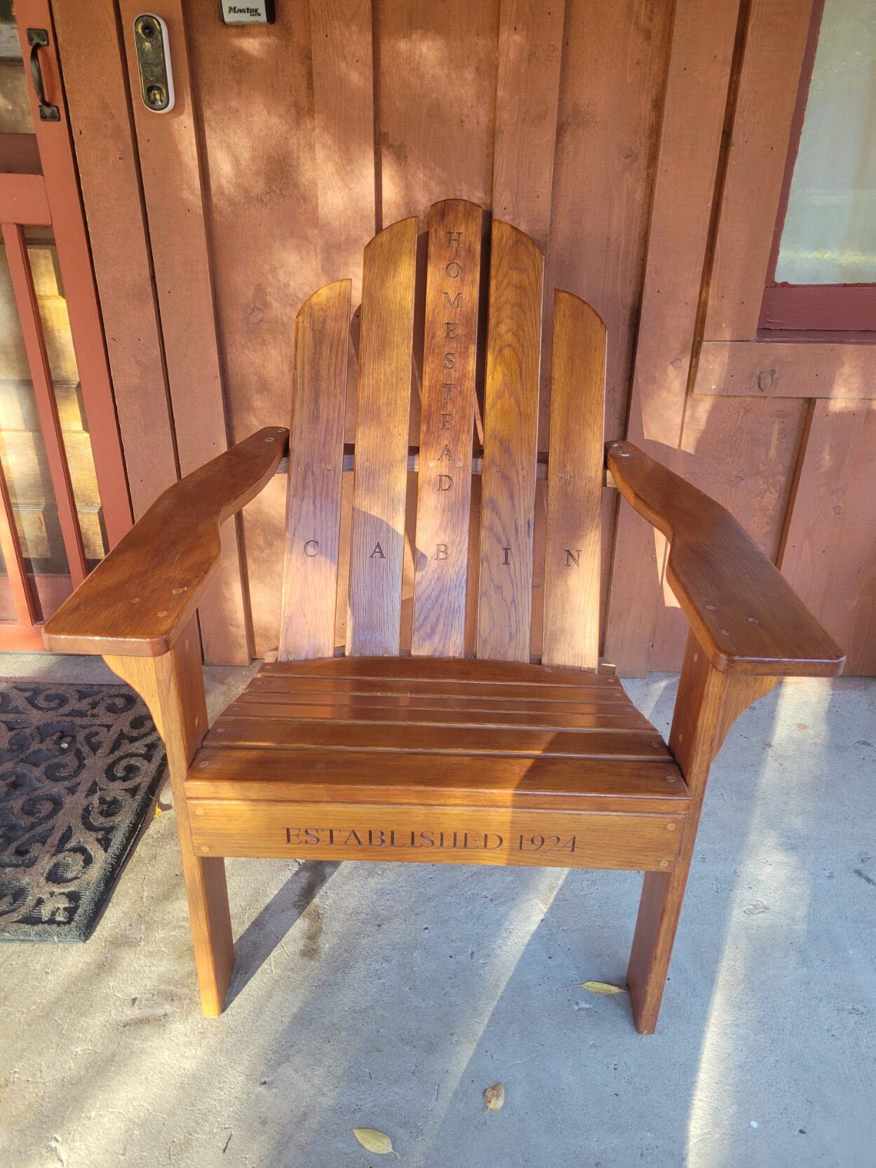 a wooden adirondak chair sitting on a porch