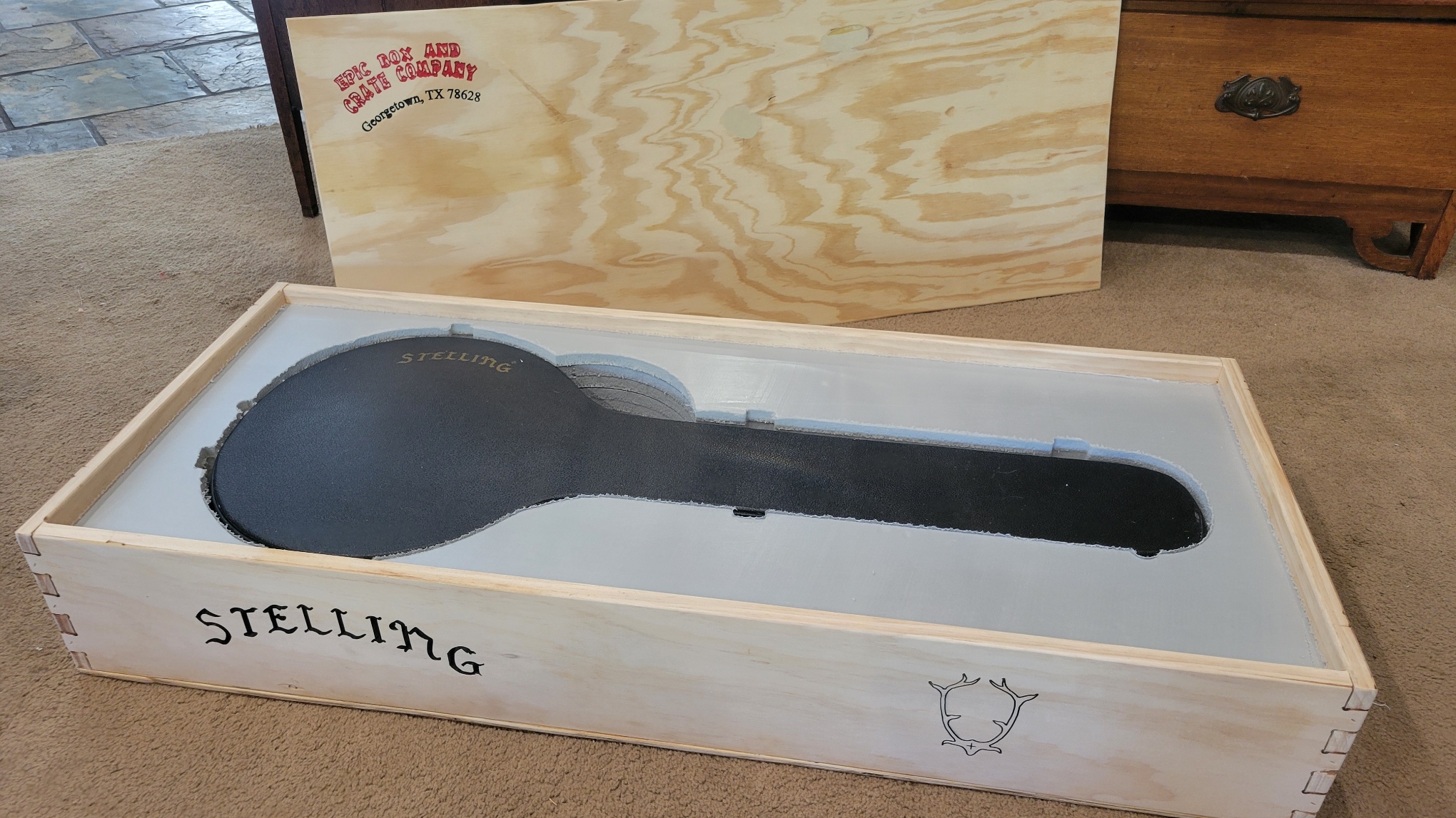 a banjo hard case inside of a custom engraved wood box with foam cut perfectly around the banjo case